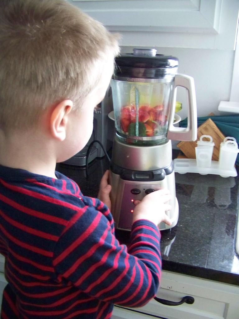 my son pushing the button on the blender